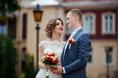 Düğün çifti, mutlu yeni evliler ve yeşil parkta kucaklaşan koca..