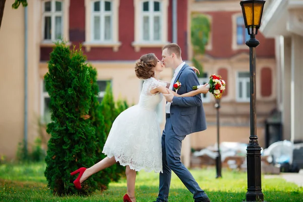 Elegáns menyasszony és vőlegény pózolnak együtt a szabadban egy esküvő napján. — Stock Fotó