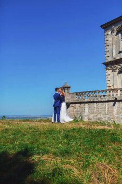 Romantik bir an. Lüks gelinlik içinde güzel bir gelin ve smokinli şık bir gelin.