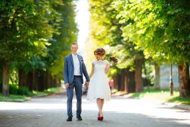 Düğün için. Genç bir çift, yeni evli, el ele tutuşuyorlar.