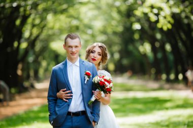 Güneşli bir günde parkta poz veren harika genç bir çift..