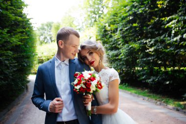 Güneşli bir günde parkta poz veren harika genç bir çift..