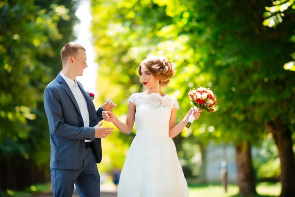 Happy bride and groom at their wedding. Newlyweds in the park. — Stock Photo, Image