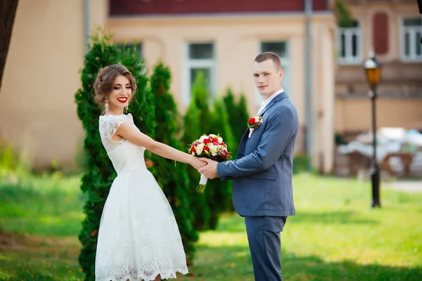 Bröllop. Unga par, nyligen gifta, håller varandra i handen — Stockfoto