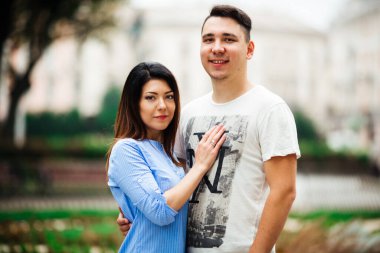 Şehrin arka planında poz veren genç çift, seyahat kavramı