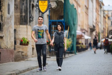 Yaz havasında bir Avrupa şehrinin sokaklarında poz veren çift.