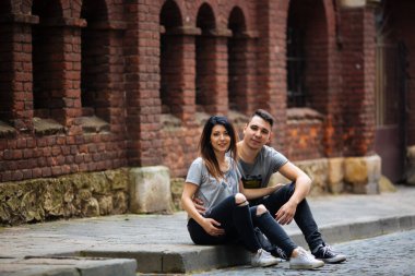 Yaz havasında bir Avrupa şehrinin sokaklarında poz veren çift.