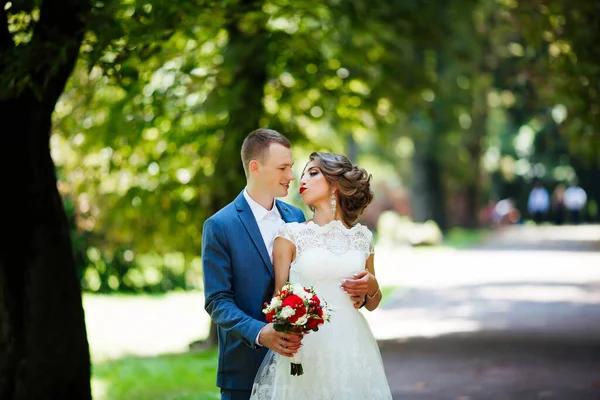 Bröllopspar, glada nygifta och make kramas i grön park. — Stockfoto