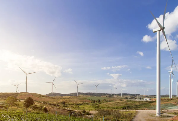 Turbinas eólicas fazenda na paisagem montanhosa contra o céu azul com — Fotografia de Stock