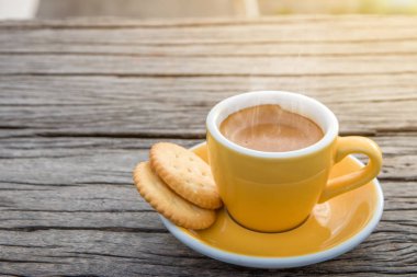 A white cup of hot espresso coffee mugs placed with cookies on a wooden floor with morning fog and moutains with sunlight background,coffee mornin clipart