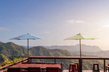 Yeşil tepelerin ve dinlenme ve şemsiye manzaralı Wat Phra 'da Pha Son Kaew Tapınağı, Khao Kho, Phetchabun, Tayland ve beyaz bulutlu mavi gökyüzü