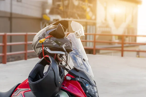 Motorcycle gloves and safety helmet hanging on a front seat of sport motorbike for safet