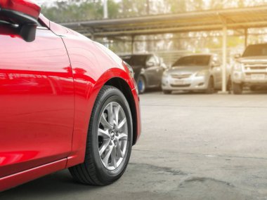 Otoparkta bir sürü arabası olan yeni kırmızı bir araba.