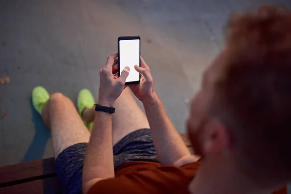 Чоловік використовує мобільний телефон у міському парку вночі . — стокове фото