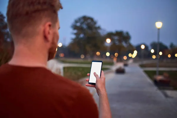 Hombre usando celular en parque urbano por la noche . —  Fotos de Stock