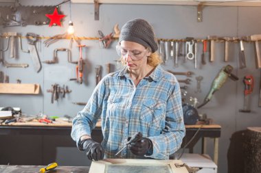 Marangoz antika bir atölyede eski ahşap üzerinde çalışıyor..