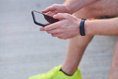 Yazın şehir merkezinde cep telefonu kullanan bir adam..