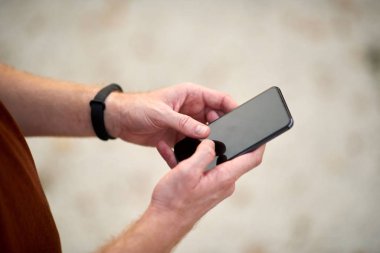 Yazın şehir merkezinde cep telefonu kullanan bir adam..