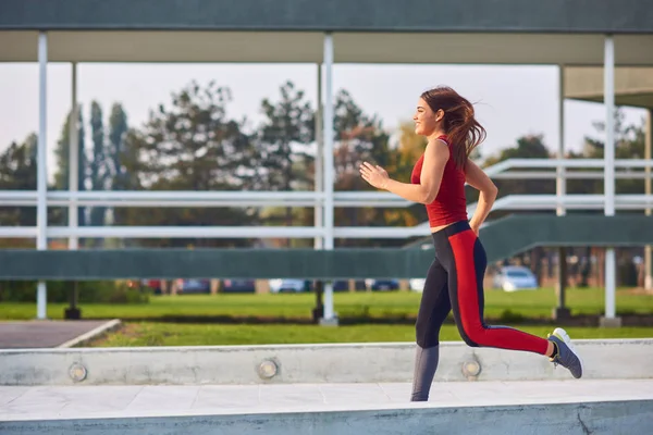 都会の公園で運動・ランニングをする若い女性. — ストック写真