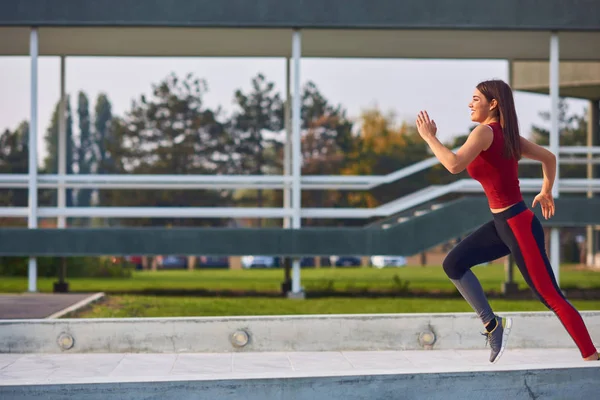 都会の公園で運動・ランニングをする若い女性. — ストック写真