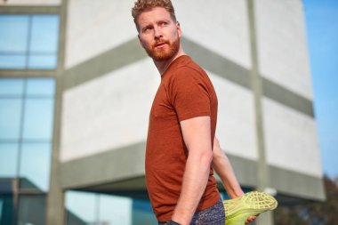 Genç adam şehir parkında egzersiz yapıyor / esniyor.