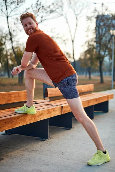 Joven haciendo ejercicio / estiramiento en parque urbano . — Foto de Stock