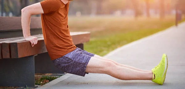 Young man exercising / stretching in urban park. — Stock Photo, Image