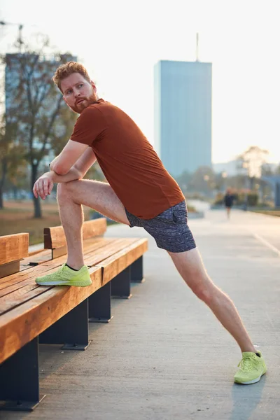 Joven haciendo ejercicio / estiramiento en parque urbano . — Foto de Stock