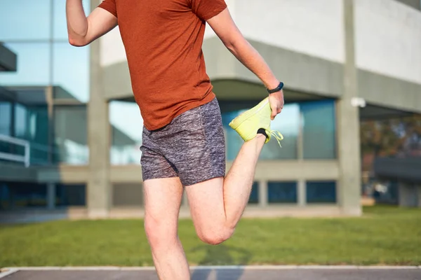 Ung man som tränar / stretchar i stadspark. — Stockfoto