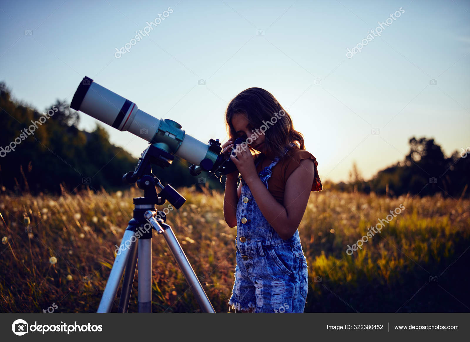 Little girl using telescope in nature to explore the universe