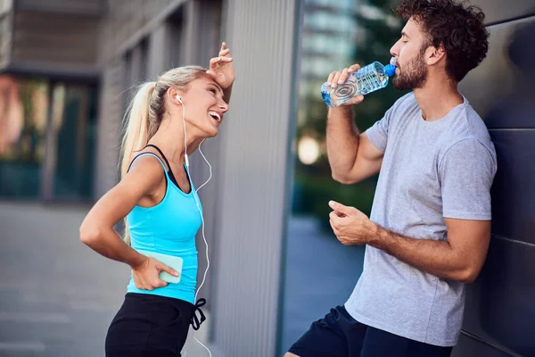 Σύγχρονη νεαρός άνδρας και γυναίκα κάνει παύση μετά από τρέξιμο / άσκηση — Φωτογραφία Αρχείου