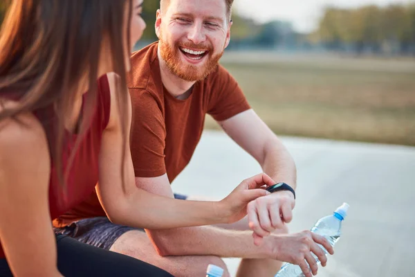 Pareja moderna haciendo una pausa en un parque urbano durante el jogging / exe — Foto de Stock