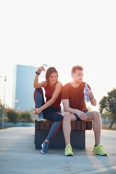 Pareja moderna haciendo una pausa en un parque urbano durante el jogging / exe — Foto de Stock