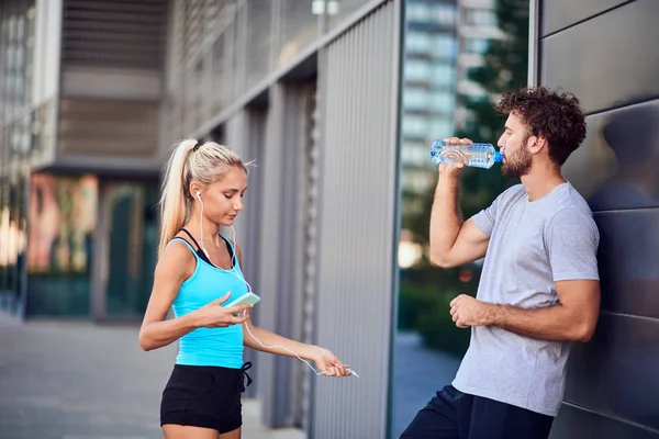 Jovem moderno e mulher fazendo pausa após jogging / exercício — Fotografia de Stock