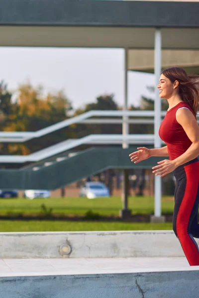 都会の公園で運動・ランニングをする若い女性. — ストック写真