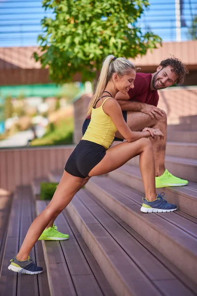 Mujer moderna y el hombre que ejercen en un entorno urbano cerca de la r — Foto de Stock