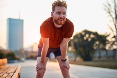 Modern genç adam şehir parkında çalışıyor..