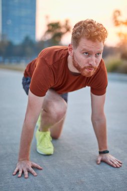 Genç modern adam şehir parkında koşuyor / egzersiz yapıyor.