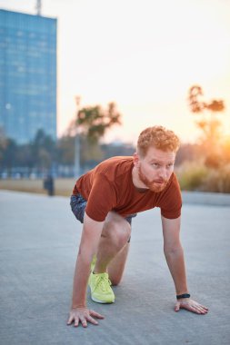Genç modern adam şehir parkında koşuyor / egzersiz yapıyor.