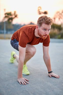 Genç modern adam şehir parkında koşuyor / egzersiz yapıyor.