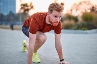 Genç modern adam şehir parkında koşuyor / egzersiz yapıyor.