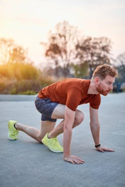 Genç modern adam şehir parkında koşuyor / egzersiz yapıyor.