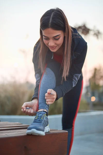 Jeune femme faisant de l'exercice dans un parc urbain . — Photo