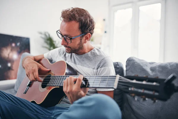 Hombre tocando la guitarra acústica en el salón . —  Fotos de Stock