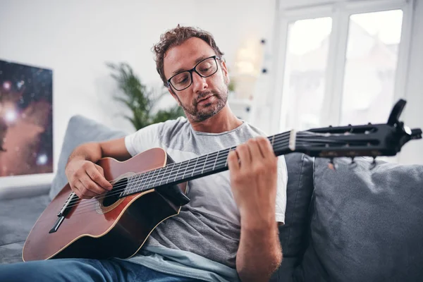 Hombre tocando la guitarra acústica en el salón . —  Fotos de Stock