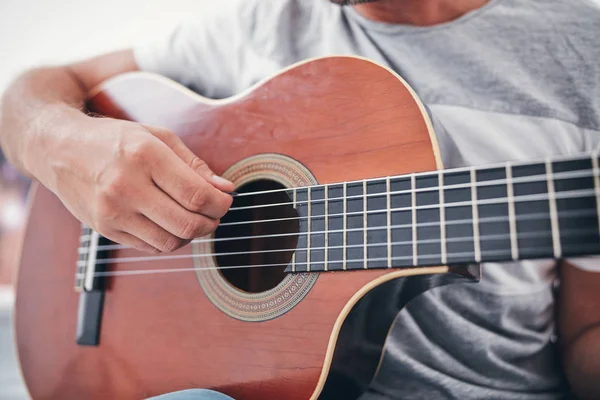 Man spelar akustisk gitarr i vardagsrummet. — Stockfoto