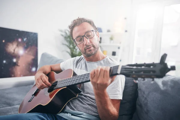 Hombre tocando la guitarra acústica en el salón . —  Fotos de Stock