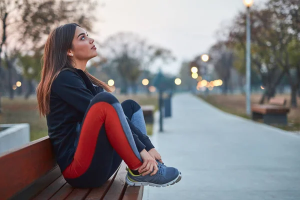Jeune femme faisant une pause après l'exercice dans un parc urbain . — Photo