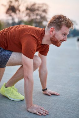 Genç modern adam şehir parkında koşuyor / egzersiz yapıyor.