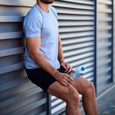 Kentsel alanda egzersiz yaparken sporcu duraklıyor.